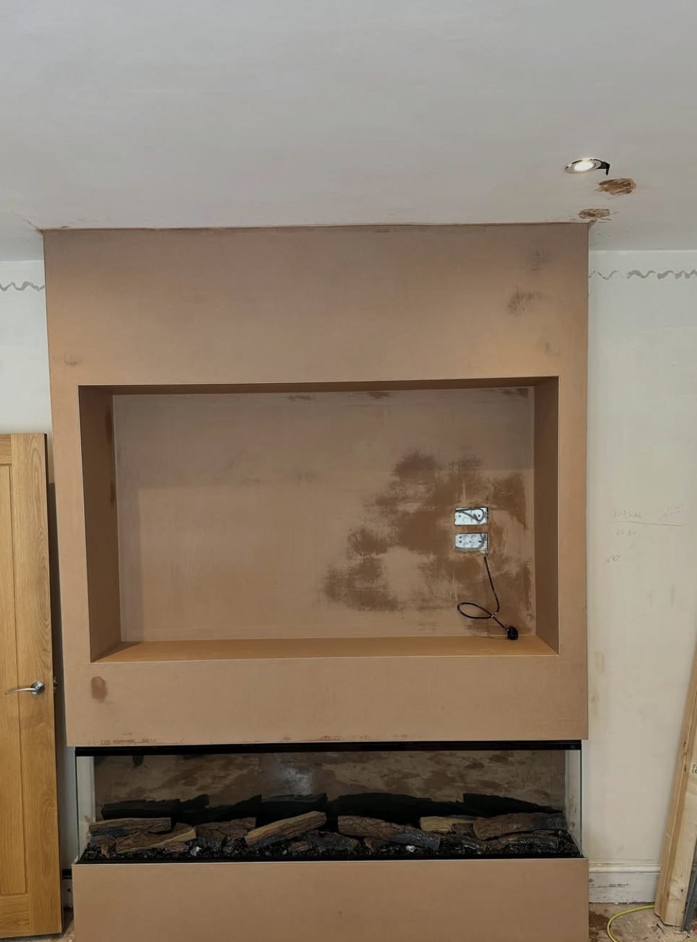 Plastered media wall with recess and inset fireplace